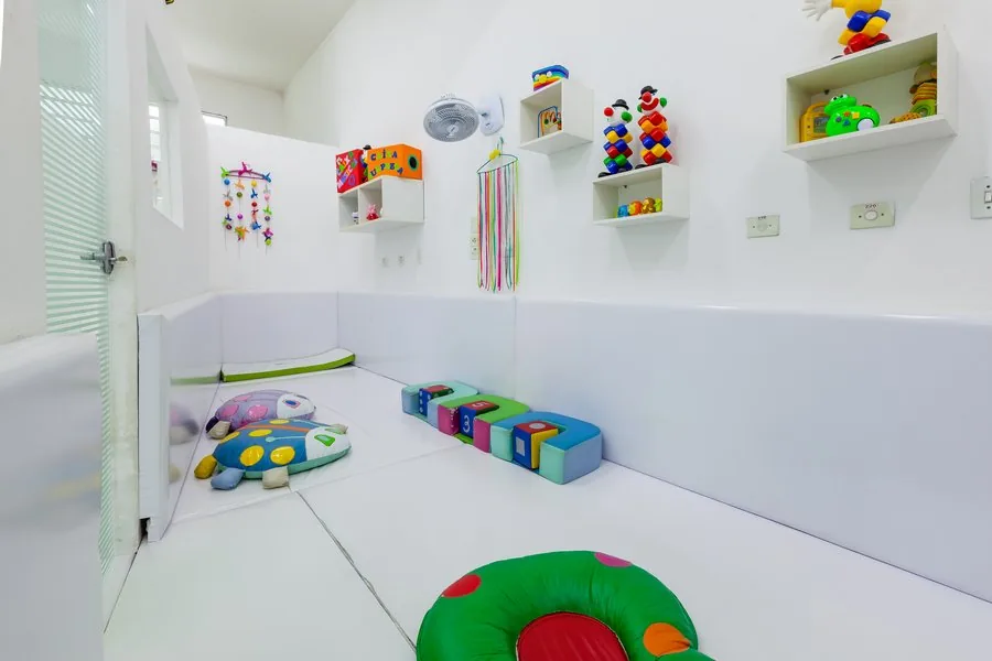 Segunda sala do berçário, com móbiles e caixas de brinquedos
